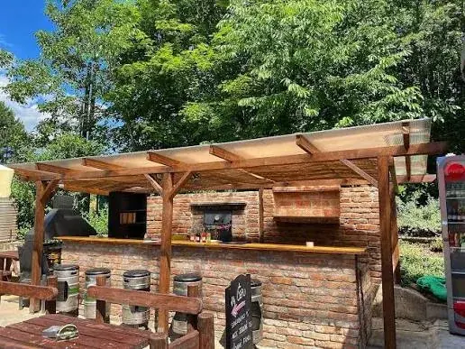 Cihlový gril bar pod dřevěnou pergolou