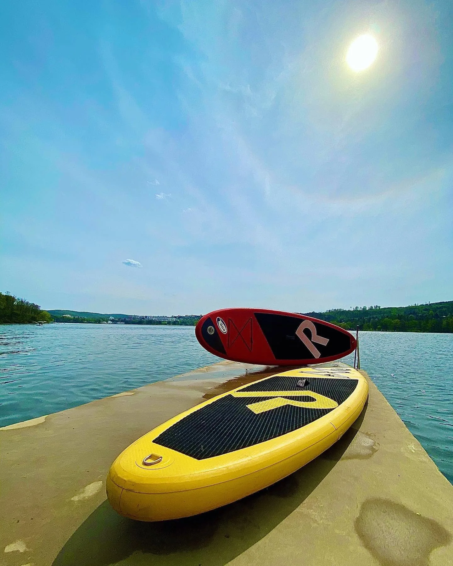 Paddleboardy na molu, v pozadí hladina Brněnské přehrady